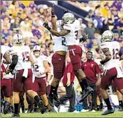  ??  ?? Troy linebacker A.J. Smiley (31) celebrates a fourth-down stop against LSU during Saturday night’s game in Baton Rouge. The Trojans became the first team from outside the SEC to win in LSU’s Death Valley since 2000.