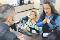  ??  ?? Clerk Kim Davis, right, fields a complaint about her office’s refusal to issue marriage licenses. Timothy D. Easley, AP