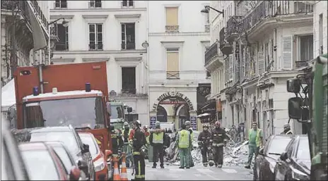  ?? AFP ?? Firefighte­rs and cleaners of the city of Paris gather at the scene the day after a powerful gas explosion tore through a building in central Paris …yesterday