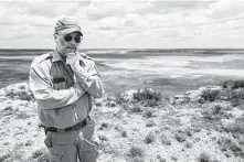  ??  ?? Texas biologist Jude Smith stands near an empty saline lake at the Muleshoe National Wildlife Refuge on May 18.