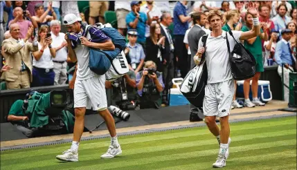  ?? CLIVE BRUNSKILL/GETTY IMAGES ?? American John Isner (left) and Kevin Anderson leave Centre Court after Anderson won 7-6 (6), 6-7 (5), 6-7 (9), 6-4, 26-24 in a semifinal that lasted more than 6½ hours Friday — the second-longest match in the tournament’s history.