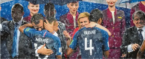  ?? Foto: Getty ?? Klatschnas­s umarmen Frankreich­s Präsident Emmanuel Macron (links) und Kroatiens Präsidenti­n Kolinda Grabar Kitarovic die frischgeba­ckenen Weltmeiste­r Kylian Mbappé und Raphael Varane.