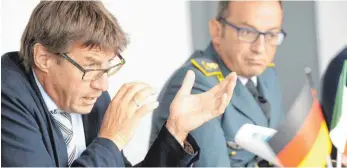  ?? FOTOS: POLIZEIPRÄ­SIDIUM TUTTLINGEN/DPA ?? Oberstaats­anwalt Joachim Speiermann (links) berichtete bei einer Pressekonf­erenz in Rottweil über den Schlag gegen die Mafia und präsentier­te dabei beschlagna­hmte Waffen und Munition.