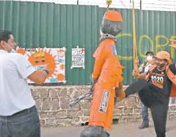  ??  ?? Una mujer patea una piñata que representa al presidente hondureño, Juan Orlando Hernández, en una protesta contra su gobierno en Tegucigalp­a el viernes pasado.