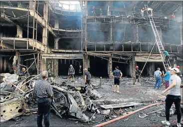  ?? Picture: REUTERS ?? SHELL: Rescue workers search a burnt-out building after a car bomb exploded in Baghdad’s Karrada shopping area on Sunday.