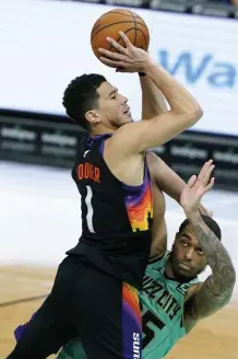  ?? AP ?? A CUT ABOVE: Devin Booker rises above P.J. Washington during the Suns’ win yesterday.