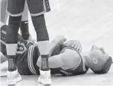  ?? JOHN BAZEMORE/AP ?? Hawks guard Bogdan Bogdanovic lies on the court after a knee injury during the first half of Game 6 against the 76ers on Friday in Atlanta.