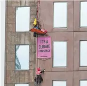  ??  ?? Greenpeace activists Abigail Smith and Nick Hanafin scaled the Majestic Centre in Wellington in a protest about oil company OMV.