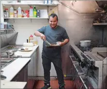  ?? SARAH GORDON/THE DAY ?? Chef Carlos Huacho finishes an order of mole con pollo.