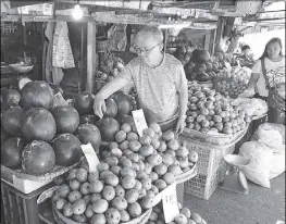  ?? ANDY ZAPATA JR. ?? A vendor attends to his stall in Baguio City yesterday where he sells fruits that abound during summer like mangoes and watermelon.