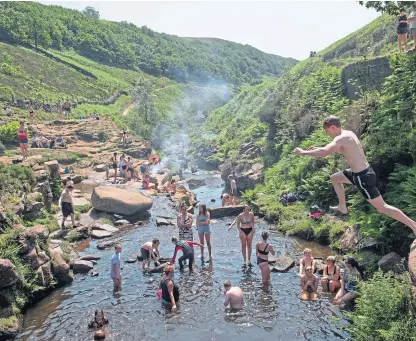  ?? Picture: PA. ?? Members of the public enjoy the hot weather by Three Shires Head on the River Dane.
