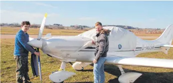  ?? FOTO: VERA ROMEU ?? Die Saison startet: Benjamin Raisch (links) und Samuel Göhring nehmen die Schutzplan­e des Leichtflug­zeugs, das ihr Segelflugz­eug in die Luft hochziehen wird, ab.