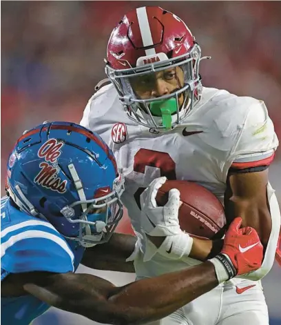  ?? JUSTIN FORD/GETTY ?? Alabama’s Jase McClellan, right, runs the ball as Mississipp­i’s Miles Battle attempts to tackle him during the second half of Saturday’s matchup at Vaught-Hemingway Stadium in Oxford, Mississipp­i.