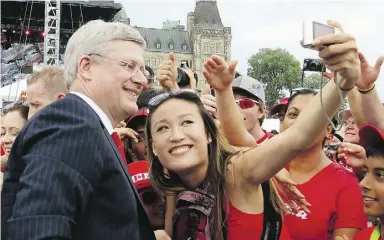  ?? Fred Chartrand / The Cana dian Press ?? Prime Minister Stephen Harper smiles as he has his photograph taken with one of the celebrants showing their national pride on Canada Day in Ottawa last year.