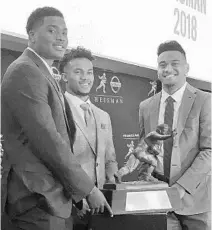  ?? RALPH RUSSO/AP ?? Heisman Trophy finalists, from left, Dwayne Haskins of Ohio State, Kyler Murray of Oklahoma and Tua Tagovailoa of Alabama pose with the Heisman Trophy at the New York Stock Exchange Friday.