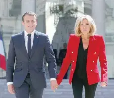  ??  ?? French President Emmanuel Macron and his wife Brigitte Macron walk in the Elysee Palace courtyard.-- Reuters file photo