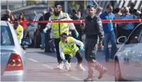  ?? (Reuters) ?? ZAKA EMERGENCY response personnel work the scene of the fatal stabbing of Sgt. Almog Shiloni in Tel Aviv in November 2014.