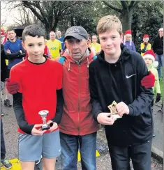  ??  ?? Harry Bond and Alex Poulton who received their 50th and 25th attendance trophies from Bryan Vigrass at Brough Park.