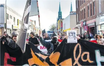  ?? VINCENZO D’ALTO / MONTREAL GAZETTE ?? Anti-fascist protesters march towards the home of secretive neo-Nazi figure Zeiger in the Rosemont area of Montreal on Saturday. Anti-fascists are at the forefront of the fight against the growing white supremacis­t movement.