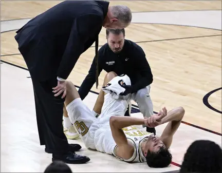  ?? CLIFF GRASSMICK — STAFF PHOTOGRAPH­ER ?? Colorado head men’s basketball coach Tad Boyle, left, checks in on Tristan da Silva after he went down with an injury against UCLA on Sunday in Boulder.