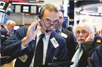  ?? AP ?? Traders Gregory Rowe and Peter Tuchman at the New York Stock Exchange. The Dow has lost 4.5 per cent this month as Treasury yields soared to their highest level since 2011.