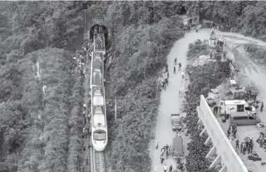  ?? SAM YEH/AFP ?? TANTANGAN MEDAN: Gambar dari udara menunjukka­n para petugas penyelamat sudah berada di lokasi kereta tergelinci­r di sekitar terowongan di Pegunungan Hualien, Taiwan Timur, kemarin (2/4).