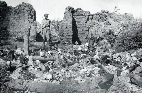  ?? ARMENIAN GENOCIDE MUSEUM- INSTITUTE / AFP / GETTY IMAGES ?? A picture released by the Armenian Genocide Museum-Institute dated 1915 purportedl­y shows soldiers standing over skulls of victims from the Armenian village of Sheyxalan during the First World War.