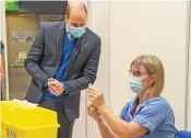  ?? (AFP) ?? Britain’s Prince William, Duke of Cambridge (left) with a healthcare profession­al at a vaccinatio­n centre, in King’s Lynn on February 22