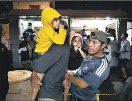  ?? Gary Coronado Los Angeles Times ?? CARAVAN members line up for food being served Monday by Mexican marines at a Tijuana sports arena, where they await a chance to request asylum in the U.S.