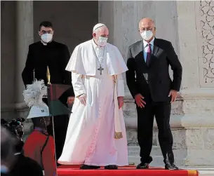  ?? ANDREW MEDICHINI THE ASSOCIATED PRESS ?? Pope Francis is welcomed by Iraqi President Barham Salih at Baghdad’s Presidenti­al Palace on Friday in the pontiff’s first trip abroad since the coronaviru­s pandemic began.