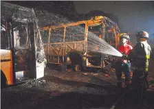  ??  ?? Bomberos realizan el enfriamien­to de una de las unidades de transporte que fue destruida en su totalidad por el fuego.