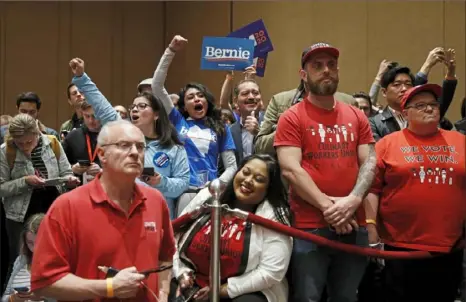  ?? John Locher/Associated Press ?? Supporters of Democratic presidenti­al candidate Sen. Bernie Sanders, I-Vt., cheer Saturday as members of the Culinary Workers Union watch during a Democratic presidenti­al caucus at the Bellagio hotel-casino in Las Vegas.