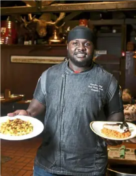  ?? Nate Guidry/Post-Gazette photos ?? Top: A dish prepared by Chef Carl Pierre-Louis, which includes panseared salmon, roasted red pepper risotto, horseradis­h creme fraiche and Creole macaroni at Carmella's | Plates &amp; Pints on the South Side. Above: Chef Carl Pierre-Louis with some of his dishes on March 10.