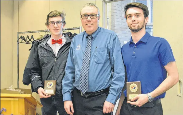  ?? TINA COMEAU ?? Liam Parker (left), 17, and Jacob Caldwell, 17, accept their coach’s award from Mark Tye during the Valley High School Hockey League banquet at the Berwick Lions Club on April 5, 2018.