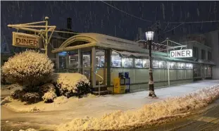  ?? ?? The Wellsboro Diner, looking like a miniature from a vintage Christmas town set, on a snowy Christmast­ime night in Wellsboro, Pa.