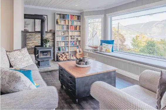  ??  ?? Visitors are pointed straight to the water view and window seat as they enter. Dark flooring and muted grey walls exude warmth. The panelled ceiling accentuate­s the cottage look.