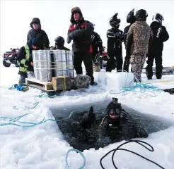  ?? PHOTO COURTOISIE, LUC MIOUSSE ?? Le plongeur et caméraman sous-marin Mario Cyr (dans l’eau) a été photograph­ié lorsqu’il est descendu sous la glace pour y déposer des barils de bière en février.