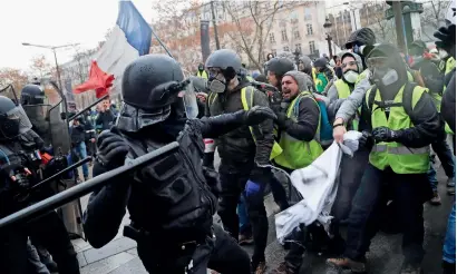  ?? AP ?? Clashes erupt as police officers block demonstrat­ors wearing yellow vests on a street in Paris on Saturday. —