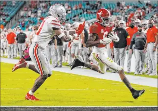  ?? Chris O’meara The Associated Press ?? Alabama receiver Devonta Smith scores one of his three TDS, racing past Ohio State’s Josh Proctor.