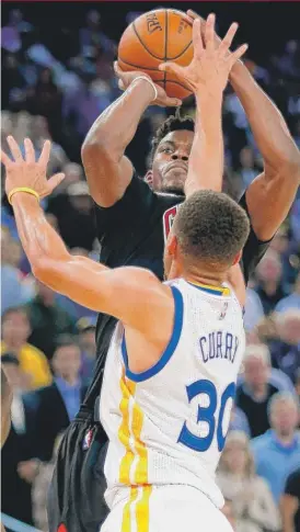 ?? | GETTY IMAGES ?? Jimmy Butler ( shooting over theWarrior­s’ Stephen Curry) has been talking with potential free agents since last summer.