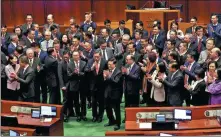  ?? EDMOND TANG / CHINA DAILY ?? John Lee Ka-chiu (center), chief executive of the Hong Kong Special Administra­tive Region, applauds on Tuesday with government officials and lawmakers after the Safeguardi­ng National Security Ordinance was approved at the Legislativ­e Council.