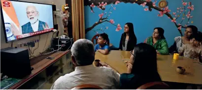  ?? AP ?? A family watches Prime Minister Narendra Modi addressing the nation on a television in Prayagraj, Uttar Pradesh, on Wednesday. —