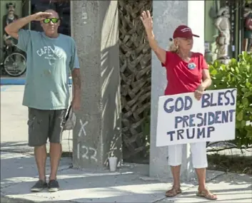  ?? Andrew Harnik/Associated Press ?? Supporters of President Donald Trump acknowledg­e his motorcade Sunday as he returns to Mar-a-lago in Palm Beach, Fla., after visiting Trump Internatio­nal Golf Club in West Palm Beach, Fla.