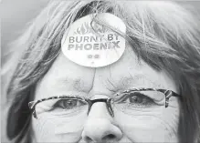  ?? JUSTIN TANG THE CANADIAN PRESS ?? Shirley Taylor wears a "Burnt by Phoenix" sticker on her forehead during a rally against the Phoenix payroll system in February.