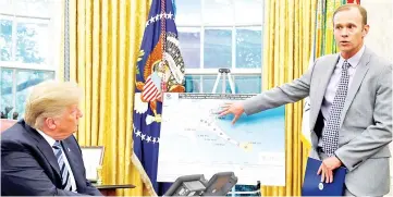  ??  ?? Trump holds an Oval Office meeting on hurricane preparatio­ns as Long points to the potential track of Hurricane Florence on a graphic at the White House in Washington, US. — Reuters photo