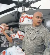  ?? JOE RAEDLE, GETTY IMAGES ?? Members of the Puerto Rican National Guard deliver food and water to hurricane survivors Friday in Lares.