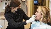  ?? BRIAN CASSELLA/CHICAGO TRIBUNE ?? Dentist Rana Stino (left) checks the retainer fit on patient Holly Brown in January at Water Tower Dental Care in Chicago. Brown wears a retainer to protect her teeth from grinding.