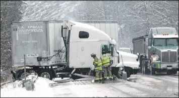  ?? HOLLY RAMER / ASSOCIATED PRESS ?? Firefighte­rs on Monday tend to a tractor trailer that went off the road on Interstate 89 North in Hopkinton, N.H. State police said the truck struck a guardrail and leaked gallons of fuel onto the road. No one was injured.