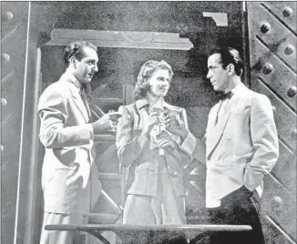  ?? United Archives GmbH / Alamy Stock Photo ?? IN “CASABLANCA,” Paul Henreid, left, Ingrid Bergman and Humphrey Bogart toast at Rick’s.