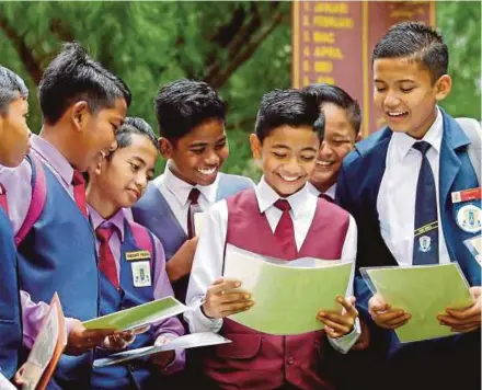  ?? FILE PIC ?? SK Seri Indera pupils receiving their Primary School Assessment Report slips in Kangar last month. Instead of the usual academic grades, holistic assessment reports of the candidates’ learning progress were given.